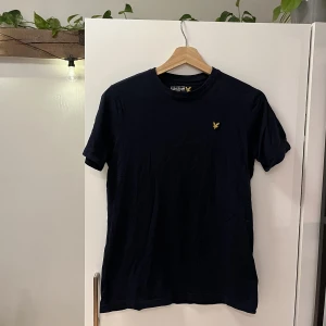 Marinblå Lyle&Scott t-shirt - Säljer en Lyle&Scott T-shirt i junior storlek 12-13 years. Den passar mig som är s/m och kommer passa alla mellan xs-m beroende på vilken passform man vill ha. Marinblå. Nypris ca 280kr. 