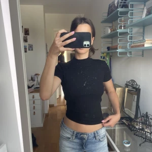 Svart t-shirt med hög krage  - Svart, ribbad T-shirt med hög krage från Zara