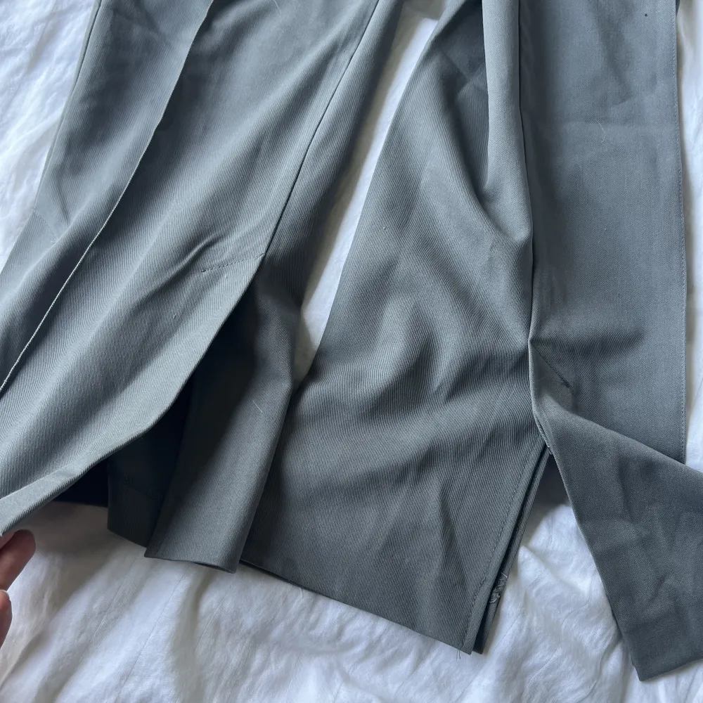 gråa kostymbyxor med liten slits längst ner från NA-KD. Jeans & Byxor.
