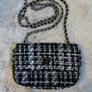 Guess väska - Säljer Guess Axelremsväska som är i jättebra skick!  11cm Höjd, 18 cm längd