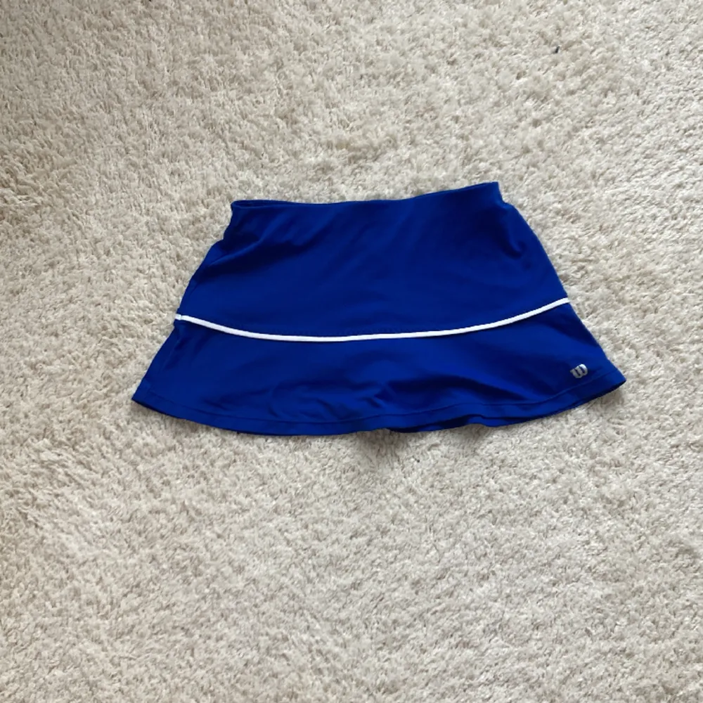 Säljer denna praktiska tenniskjol med inbyggda shorts, då den är förliten. Den är i storlek 140.. Kjolar.
