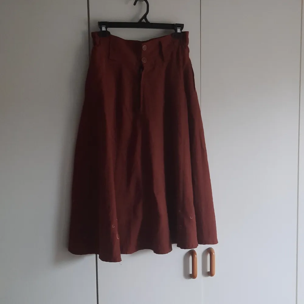 Vintage kjol med broderi och träknappar. Lite sliten i dragkedja och tyg men fortfarande väldigt fin.  Den har fickor. . Kjolar.