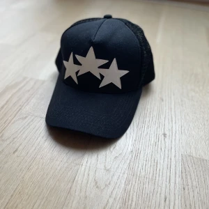 Amiri Tre Stjärnor Keps - Svart Amiri keps med tre stjärnor i perfekt skick. Har aldrig använt den så bestämde mig för att sälja den. Går att justera storleken.