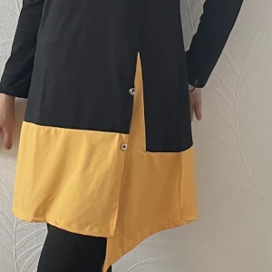 Burkini - Helt ny Burkini i polyester och lycra, svart med snygga orange detaljer. Enbart provat med  underkläder på. Aldrig använt. Storlek är ganska generös S med längd på byxan 98cm och överdelen är 89 cm lång från axeln mätt. 