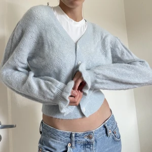 Söt babyblå cardigan - Superfin och mysig cropped cardigan med unika räfflade ärmar från & Other Stories i storlek S.  Använd men i fint skick! 