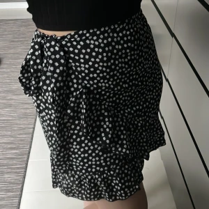 Kjol - Kort kjol med volangdetaljer och knytning i midjan!