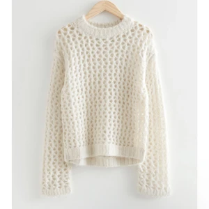 Oversized hålstickad vit & Other stories - Intressebolag på denna otroliga stickade tröja från & Other stories. Den är tillverkad i Ullmix och är i nyskick. Den går både att klä upp och klä ner! Slutsåld överallt, nypris 1300kr! Skriv vid intresse. Passar S-M