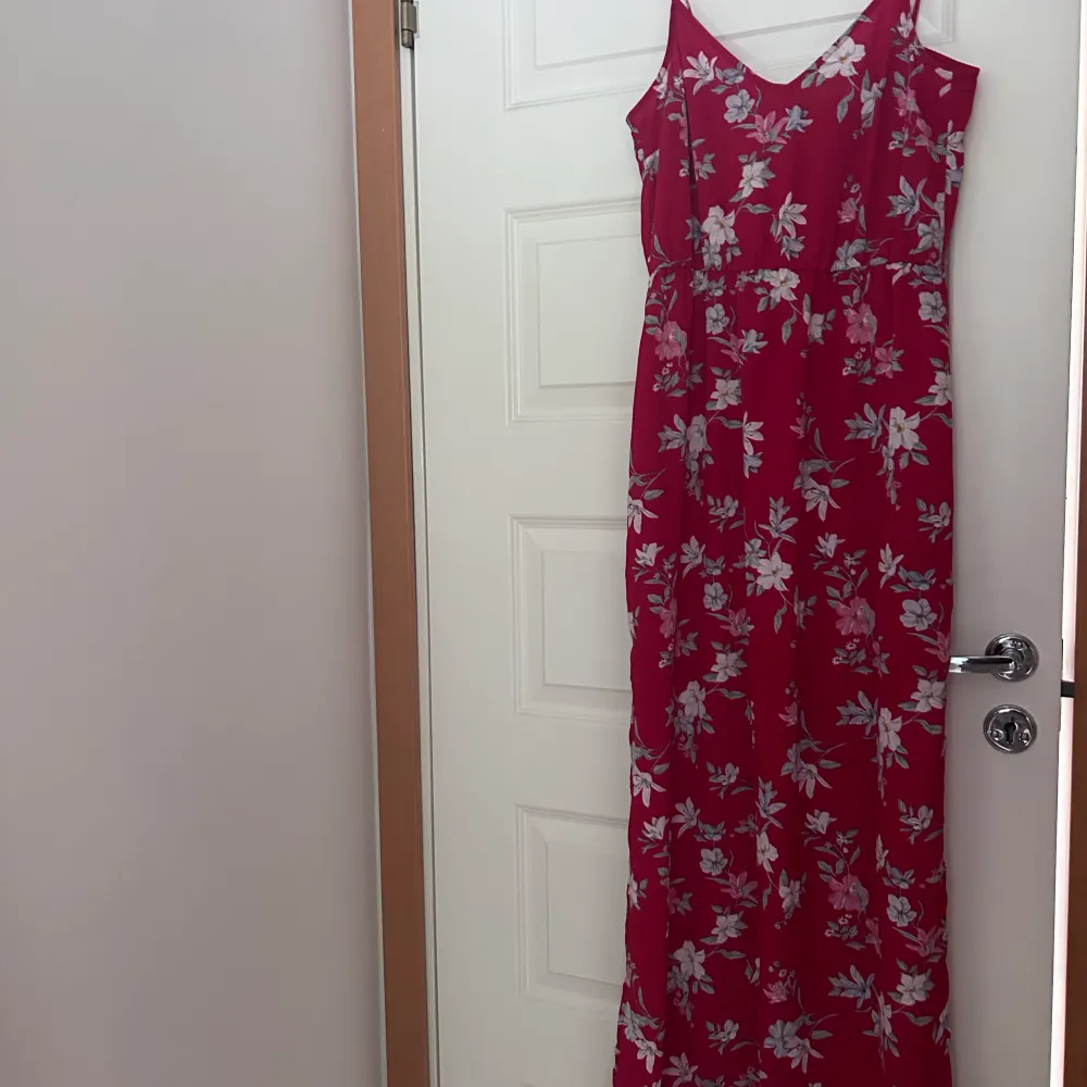 En röd långklänning med Blom detaljer. Köpt på hm. Använt en gång! Passar så bra till dop/ bröllop men även middag eller liknande. Har resor under bysten. Så så så fin! . Klänningar.