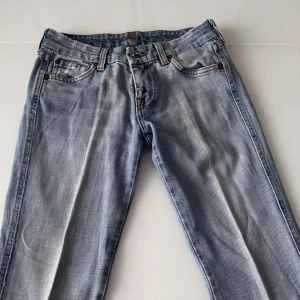 Lågmidjade jeans  - Ljusblå lågmidjade bootcut jeans från 7 for all mankind. Storlek 25