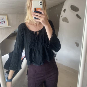 Svart topp - Svart gullig topp med detaljer i fram 