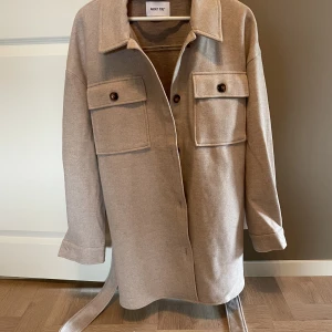 Kappa - En kappa med knäppning, helt ny men utan lappar.  Stl L