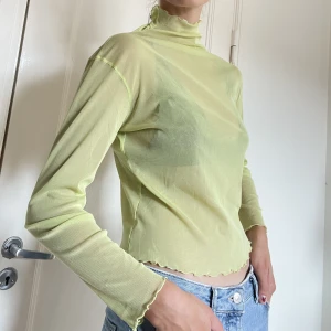 Meshtopp  - Limegrön långärmad meshtopp med hög krage! Det står ingen storlek i tröjan, men den är oversized på mig (S) och sitter säkert perfekt tight och snyggt på M 🥰