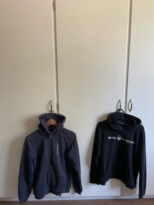 Sail racing zip and hoodie 2st - Två st sail racing tröjor i strl 170 passar även xs-S färg svart och blå 