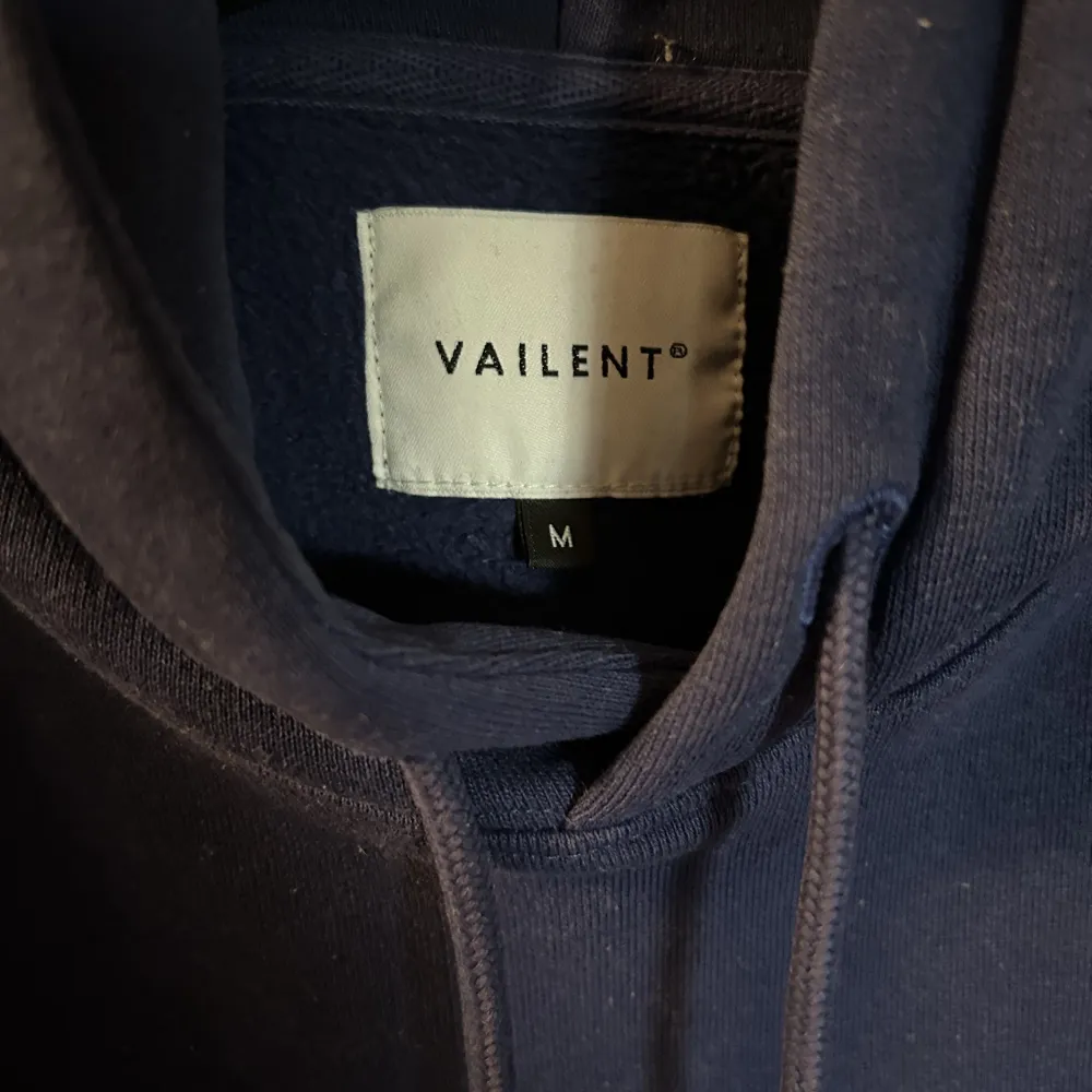 En mörkblå hoodie från valient (köpt på carlings) med ett stort och snyggt tryck på ryggen. Storlek M. Bra skick.. Hoodies.