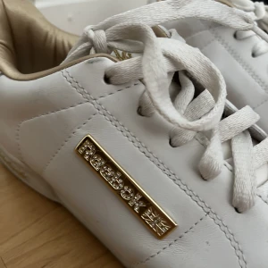 Reebok sneakers  - Sneakers från Reebok med gulddetaljer. 