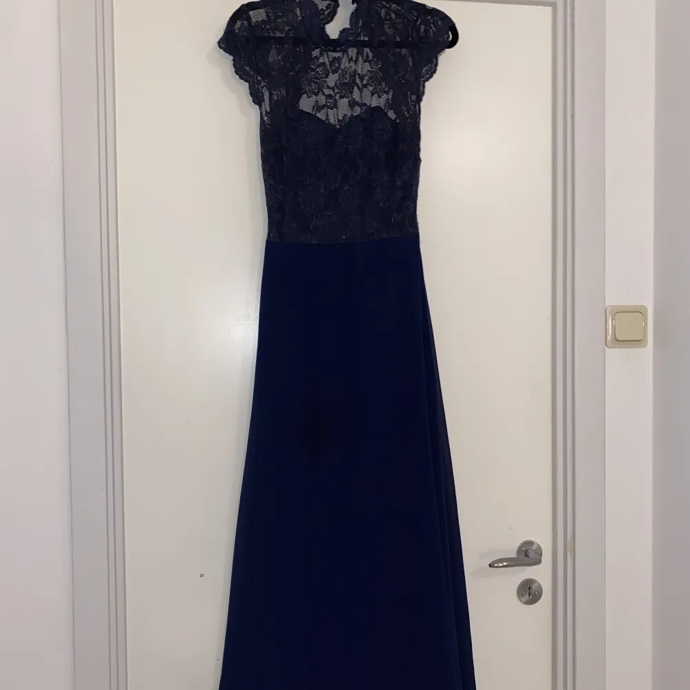 Säljer denna fina mörkblåa klänningen som är med spets och en öppen rygg. Klänningar.