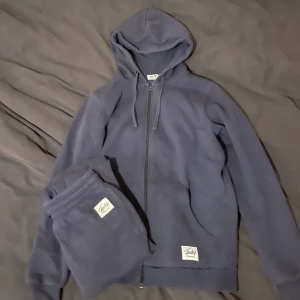 Frank Dandy Set - Säljer mitt Frank dandy set då det inte kommer till användning längre. Använda men i bra skick. Mörkblå färg och mysig inuti. Storlek S men skulle passa M också då det är i herrmodell egentligen men inget som märks. Lite oversized. Köpt för 450kr. 