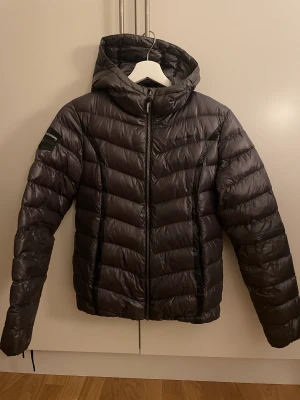 Vinterjacka  - Tunnare dunjacka från Halvarsson.  Stl: S  Mörkgrå  Säljes då den tyvärr inte kommer till användning. Skriv för mer bilder etc.  Nypris: 1000:- Frakt tillkommer 