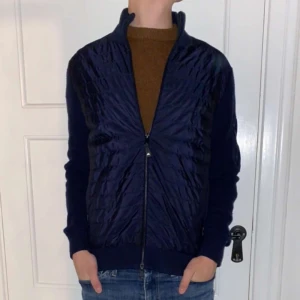 J.Lindeberg Cardigan - Säljer denna mörkblåa super feta Cardigan från J.Lindeberg. Jackan är i toppen skick utan några skavanker eller defekter. Modellen på bilden är 186cm och väger 70kg