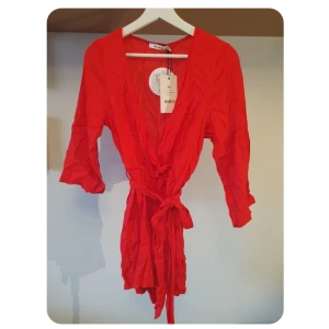 Oanvänd playsuit (lappar kvar)  - Oanvänd röd jumpsuit / playsuit / byxdress från NAKD. Köpte men var för liten & glömde skicka tillbaka så lapparna är fortfarande på ❤️ band som man knyter i midjan. Storlek XS men passar XS-S
