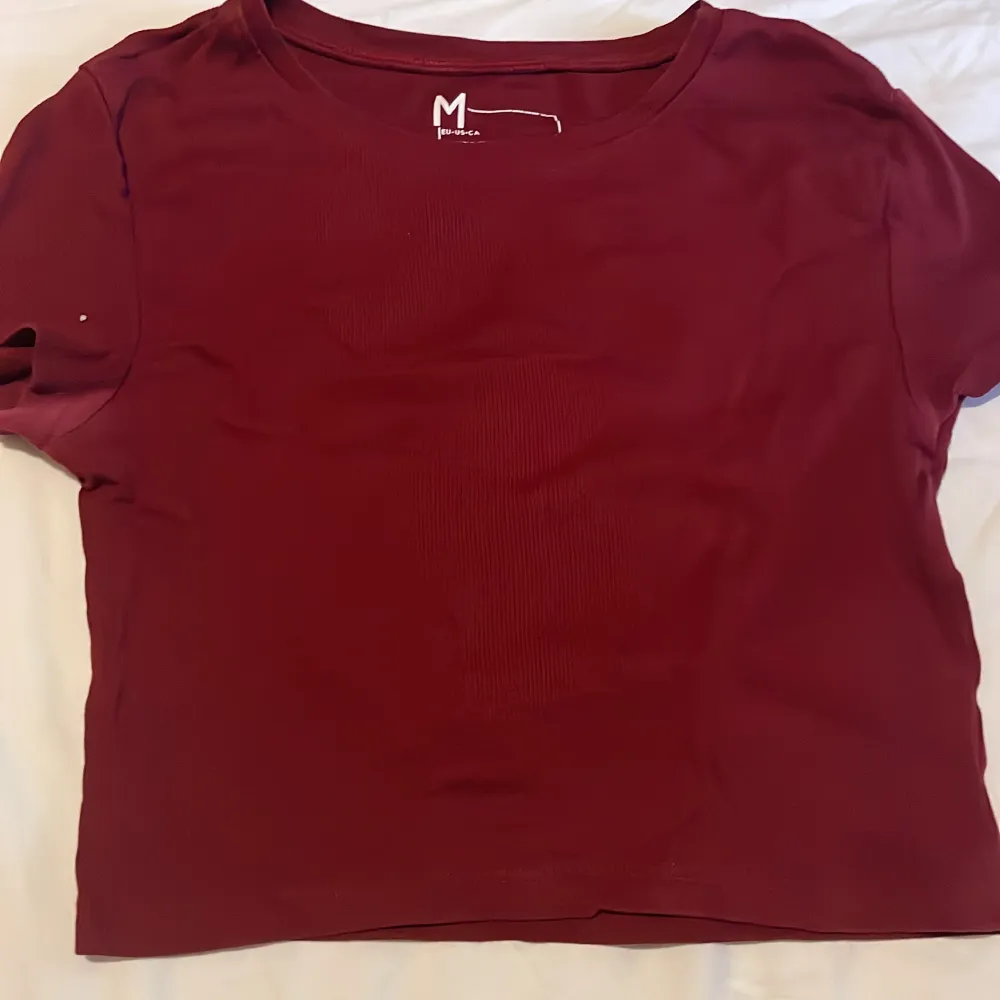 En helt vanlig tröja i en supersnygg röd färg! Skulle dock säga att den är lite mer som en croptop då den inte går hela vägen över magen 🥰. T-shirts.