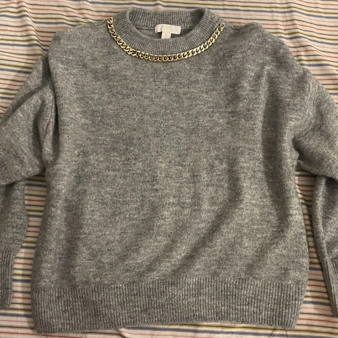 Grå tröja med guldkedja