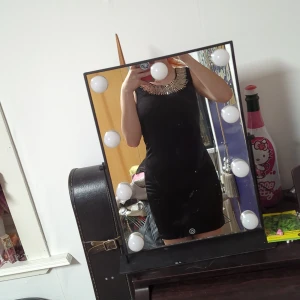 Klänning - En svart klänning med silver detaljer som dock blivit lite missfärgade.