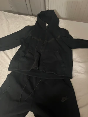 Svart Nike tech  - Svart Nike tech sett i storlek S, tröjan har ett litet hål på ena fickan men inget man märker av!