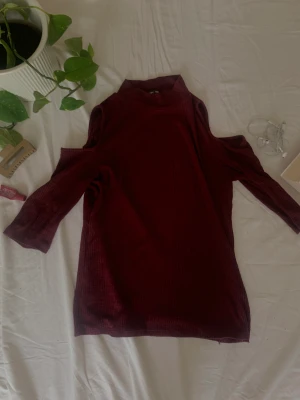 Vinröd tröja - Vinröd långärmad tröja med hål över axlarna. Skönt material. Väldigt bra skick.