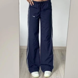 Nike byxor  - Lånad bild från internet. Likande vintage Nike blå byxor i ny skick. Dem har mjukt material inne så dem är väldigt sköna jag har tröttnat på den så nu säljer jag dem!! Sista bilden är mina!! 