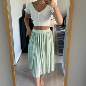 Mintgrön Midi kjol och vit topp - Säljer min fina mintgröna NA-KD kjol! Plisserad kjol i strlk XS. Säljs för 200kr   Säljer även den vita toppen från princess polly, strlk 32/34, sitter supersnyggt. Pris: 150