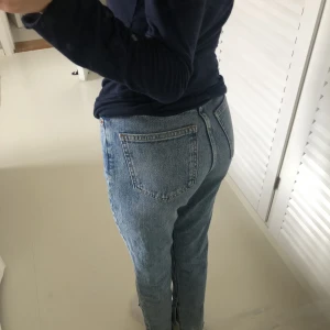 Blåa jeans - Ett par blåa jeans med slits från Gina Tricot. Storlek 30, fint skick! Köparen står för frakten💙