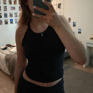 Linne - Säljer ett svart linne med små volanger på sidorna. Väldigt skönt material och som passar till allt. Passar en som är i storlek S💕