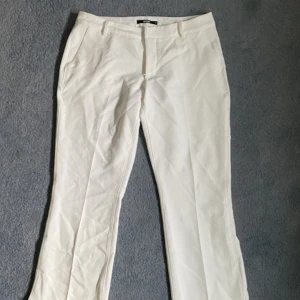 Bootcut kostymbyxor  - Skit snygga vita kostymbyxor från bikbok. De är bootcut och har en slits vit fotleden. 