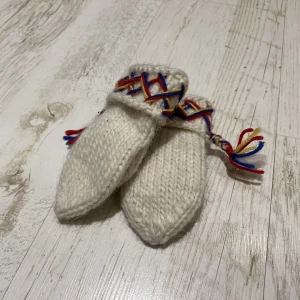 Handstickade barnvantar - Handstickade barnvantar i väldigt fint skick då de är sparsamt använda.  De ser lätt smutsiga ut på vissa ställen men det stämmer inte, det är skuggningar av garnet när bilderna tas 🙂  Yttermått ——————— Längd: 16cm Bredd: 8cm