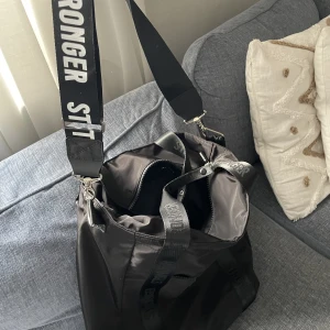 Träningsväska från Stronger  - Träningsväska knappt använd. Från Stronger. Både axelband och med vanligt handtag.