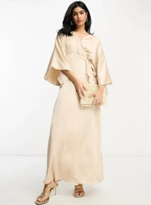 Beige maxiklänning i satin - - Beige maxiklänning i satin med omlottdesign och kimonoarmar  - Modellen är 176,5cm och bär storlek 36 - Köpt för 639kr 