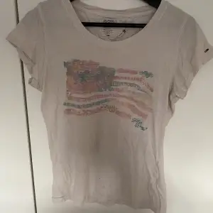 T-shirt med tryck från Tommy hilfiger i storlek SX/s. De finns tyvärr små hål på tröja men dom syns knappt🤭💕
