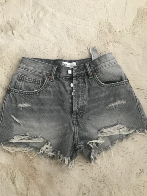 Gråa zara shots - Säljer mina gråa lågmidjade zara shots som är helt nya då de aldrig är använda. Säljer då de aldrig kommit till användning, har bara använt 2 gånger.