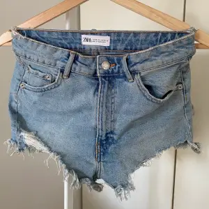 Blå shorts med slitningar från Zara, storlek 34. Knappt använda och är i fint skick.