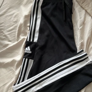 Adidas byxor - Svarta adidas byxor med dragkedja på fickorna och längst ner på byxorna, köpta på intersport, aldrig använda  