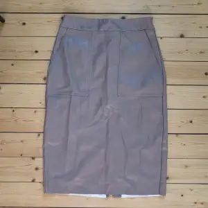 Knee long skirt, size 36 from Nelly trend. Faux leather in light taupe/brown. Good condition 