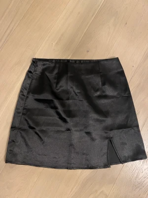Kjol med slits  - Aldrig använd, nytt skick. Plaggets material är silke. 