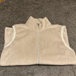 Konståknings väst  - Beige konståkningsväst från Sagester i mjukt material. Mycket bra skick. Använd få gånger. Nypris ca 1100kr
