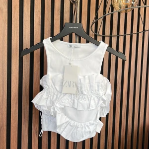 Topp  - Topp med volang. Man sätter in ärmarna så att den blir lite off shoulder. Inte kommit till användning så säljer. Prislapp kvar osv. 