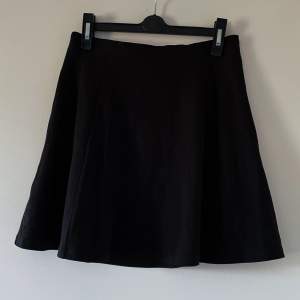 En kort svart kjol. Vid och utsvängd modell. Använd men i ett väldigt gott skick. 