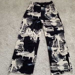 H&M kostymbyxor svart/beige mönster - Strl 38, aldrig använda kostymbyxor i polyester. Lite långa i benen för mig som är 162cm, men funkar med ett par högre boots. 