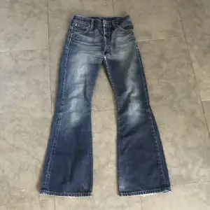 Mörkblå Levis utsvängda / bootcut jeans. Köpta second hand. Storlek 27. Innerbenslängd: 76 cm, midjemått rakt över: 35 cm. För små för mig :( 
