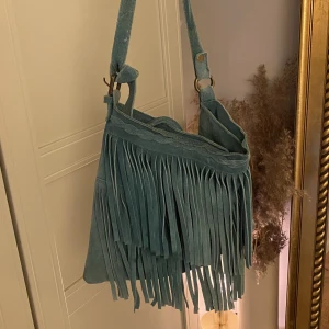 Frans väska  - Super fin väska från indiska, man kan reglera bandet är i hyfsat bra skick är lite sliten 