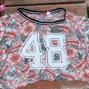 Cropped t-shirt  - Blommig cropped t-shirt, lös passform 